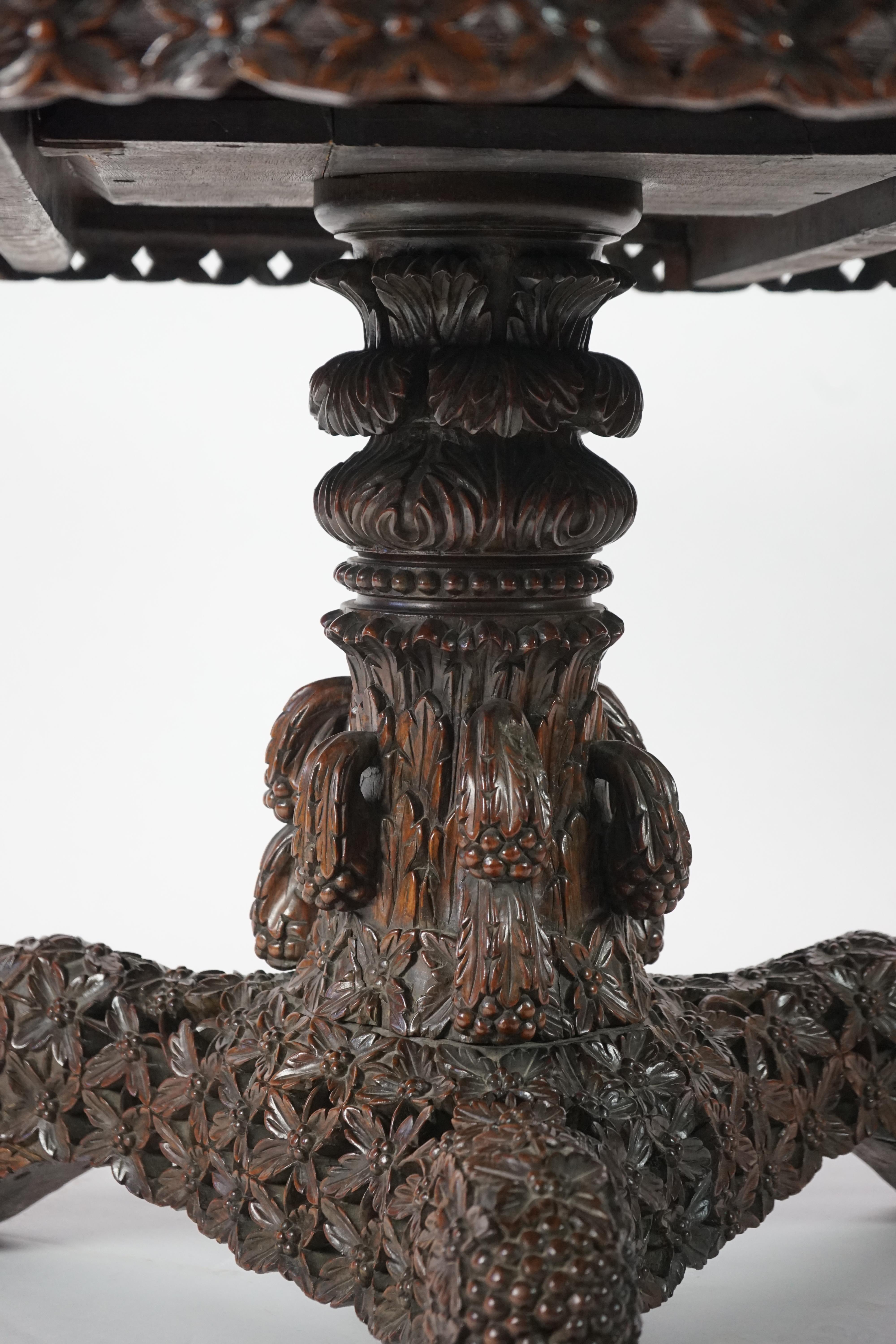 A 19th century Anglo-Indian hardwood foliate carved tilt top centre table